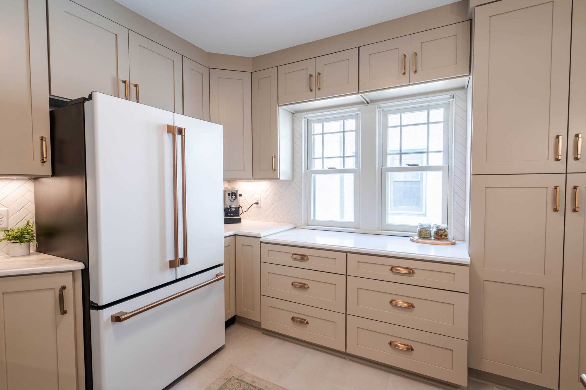 Minneapolis kitchen remodel with custom cabinetry, quartz countertops, built-in storage, and herringbone tile backsplash.