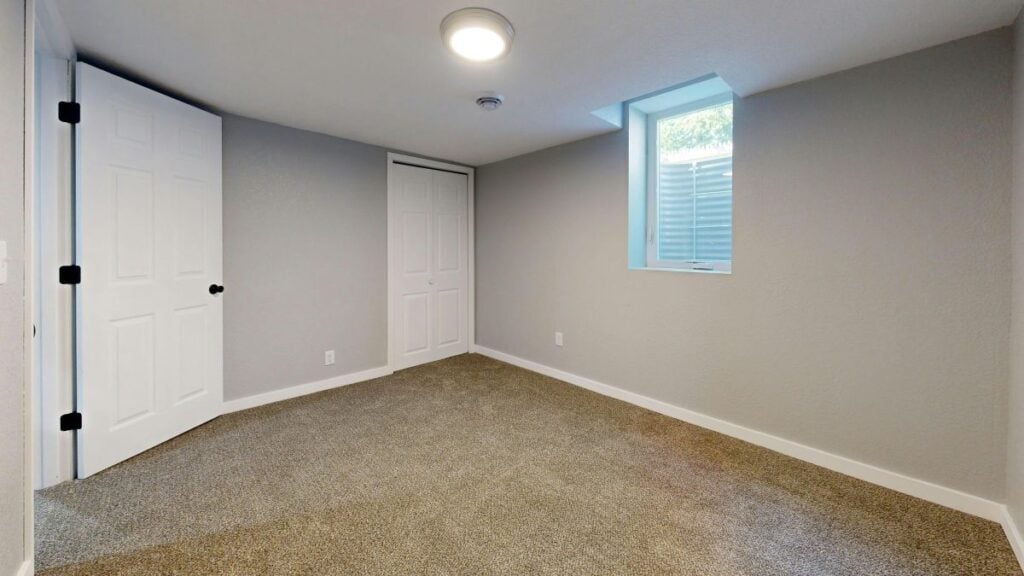 Bedroom in finished basement with egress window.