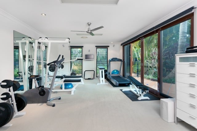at-home gym inside remodeled basement area with treadmill, weight machines, and other equipment with storage