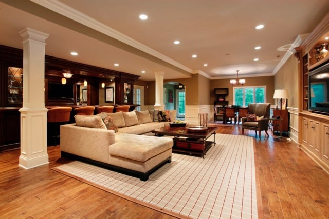 finished basement with bar with stools and multiple seating areas and built in entertainment center