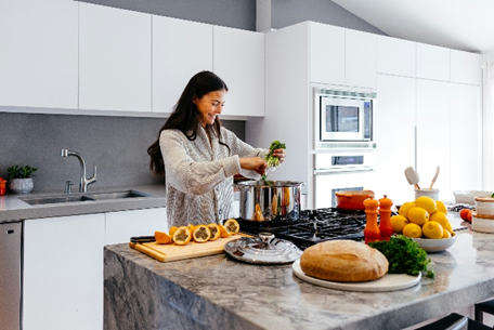 Person preparing food at a kitchen island with stone countertop