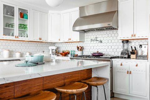 White modern kitchen with marble countertops and island seating 