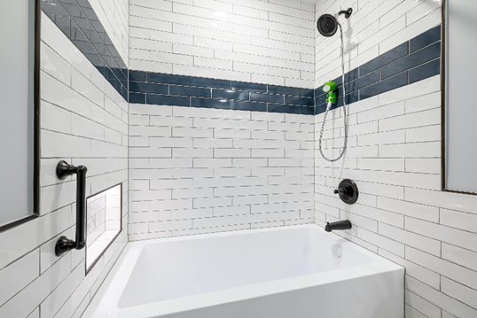Remodeled bathroom with tile tub surround and built in niche 