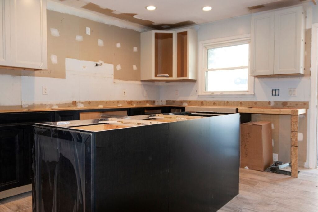 Kitchen remodel in progress with unfinished cabinets and countertops