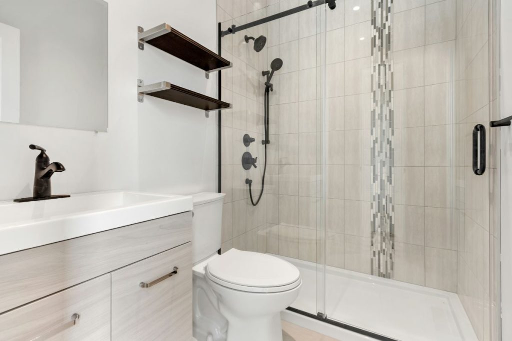 remodeled bathroom with floating shelves above toilet