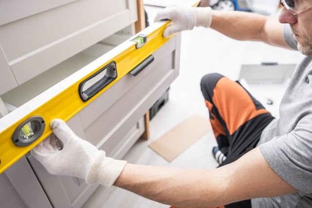 kitchen remodeling contractor fitting kitchen cabinets during install