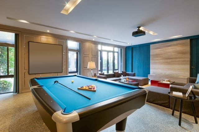 upscale recreation game room in basement with pool table, projector on wall and lots of seating