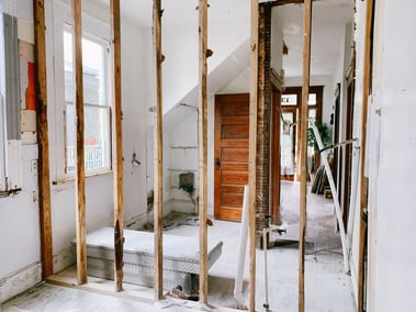image                Bathroom remodel in progress with exposed wall framing, plumbing rough-ins, and unfinished surfaces during construction.