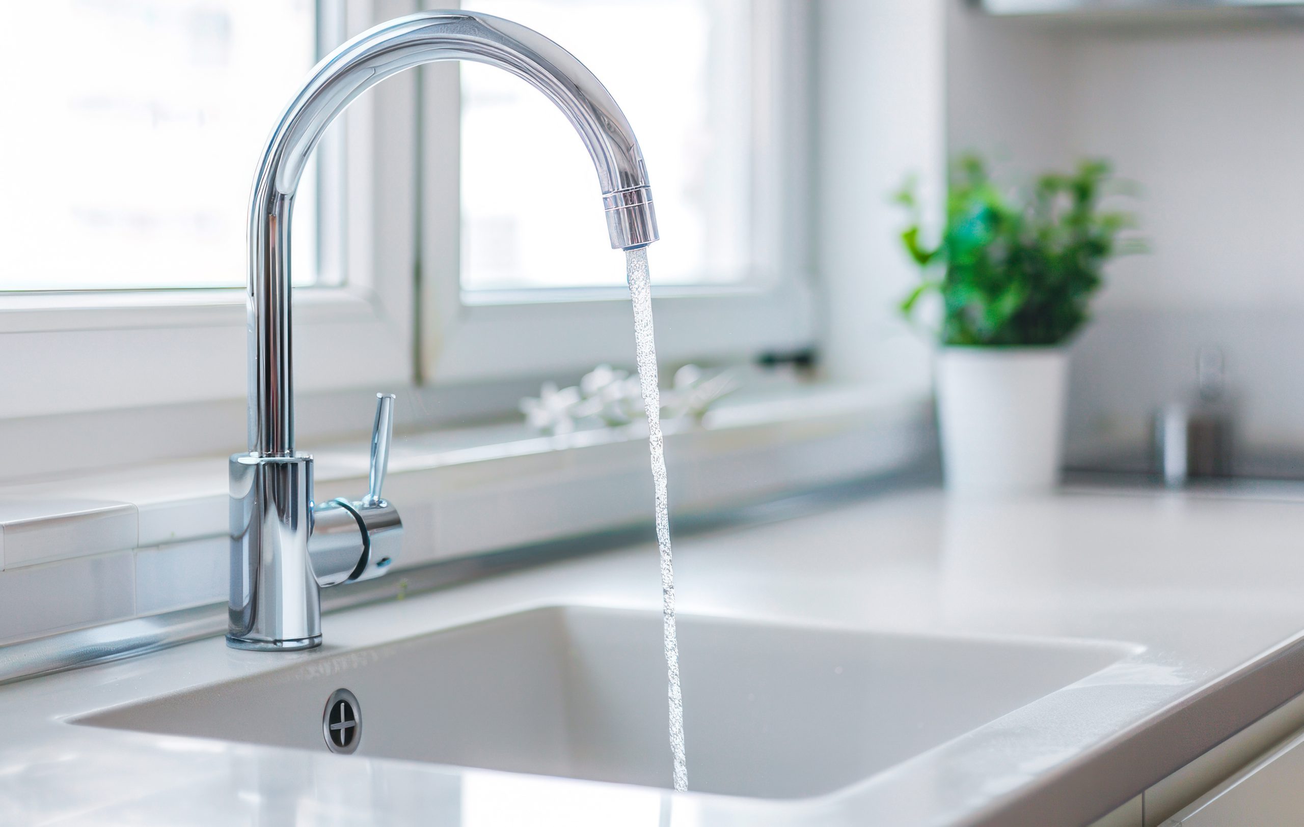 Modern white kitchen sink with chrome faucet