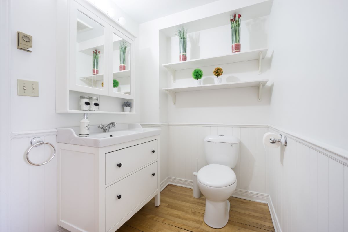 remodeled small bathroom with floating shelves and cabinet storage