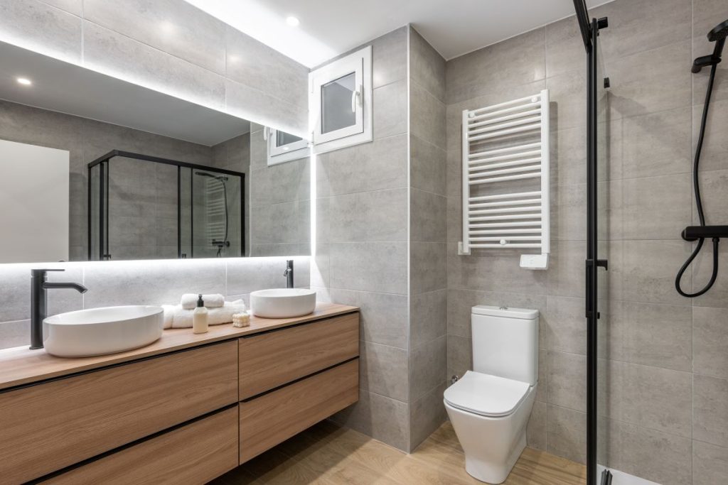 Sleek, modern bathroom with a floating wood vanity, dual vessel sinks, and LED smart mirror