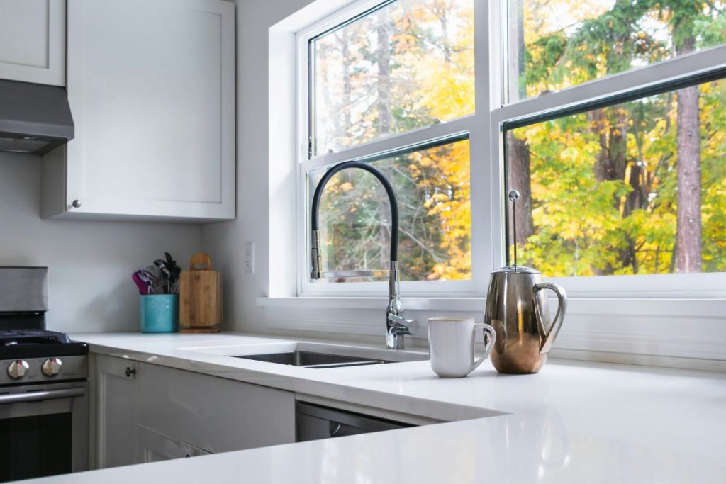 Bright kitchen with large window behind sink