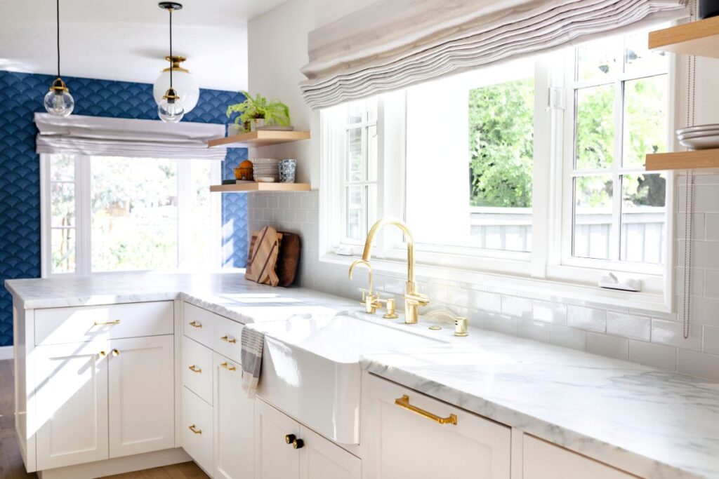 Remodeled kitchen with farmhouse style sink and marble countertops