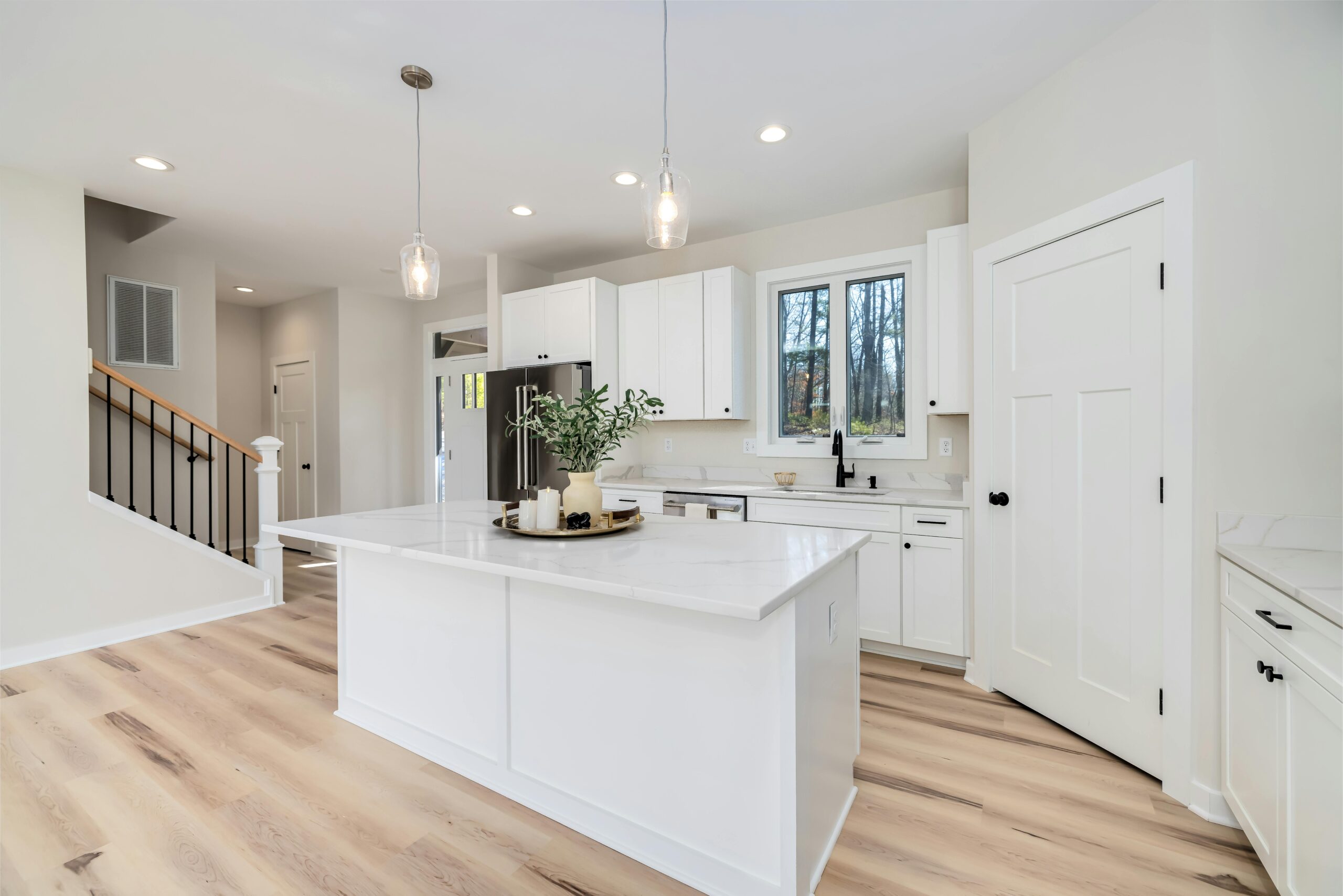 Bright remodeled kitchen with white cabinetry and quartz countertops