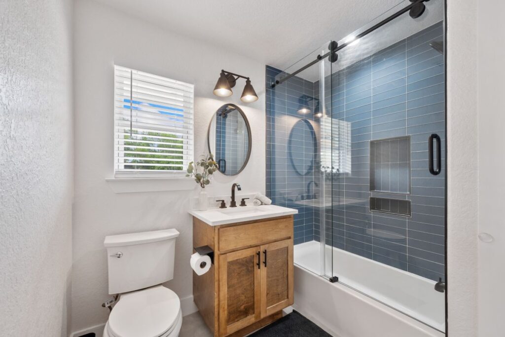 Newly renovated bathroom with blue tile tub surround