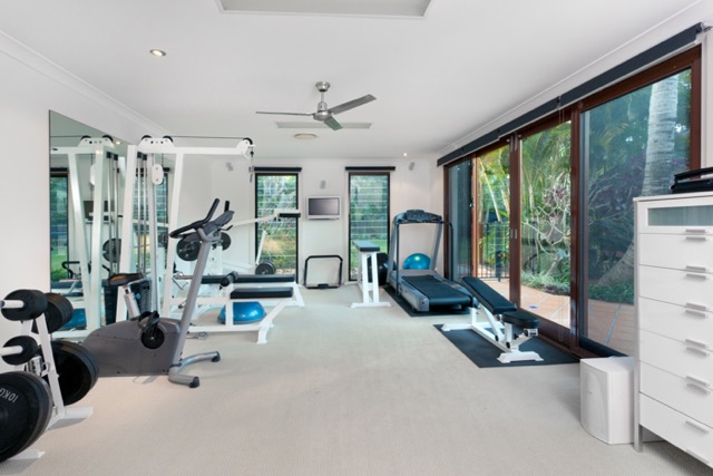at-home gym inside remodeled basement area with treadmill, weight machines, and other equipment with storage