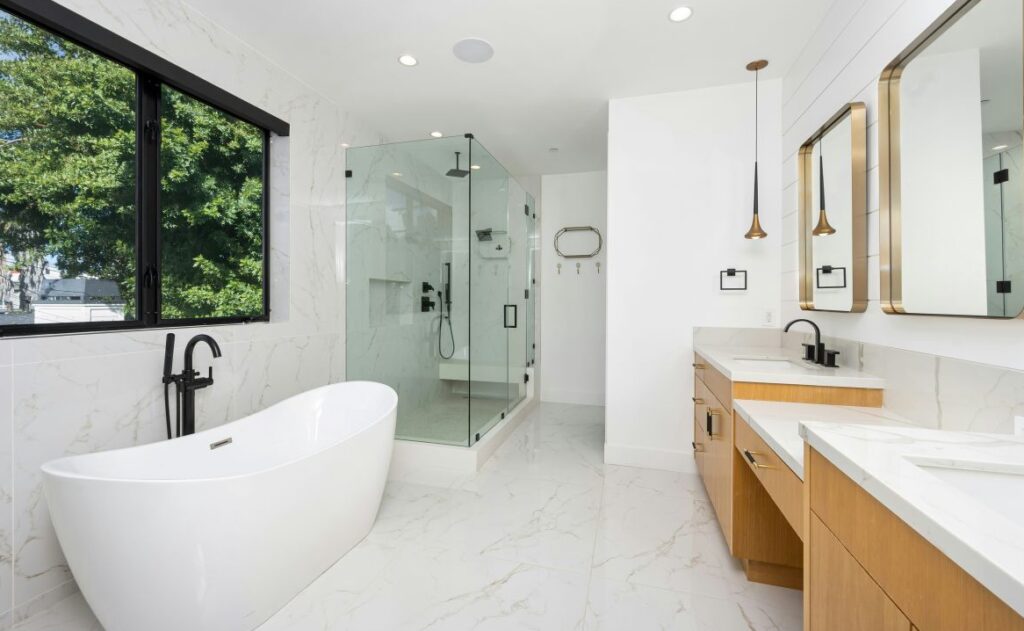 Bright primary bathroom with large soaking tub and separate glass shower