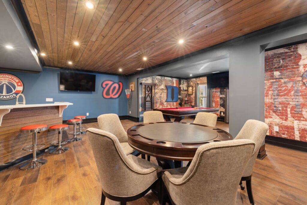 Finished basement with a custom bar, poker table, pool table, wood ceiling, and entertainment area.