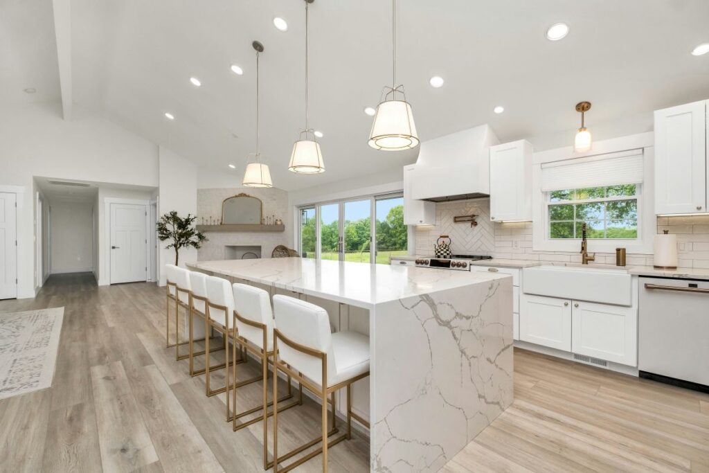 Bright modern kitchen with a quartz waterfall island, pendant lighting, and seating for four.
