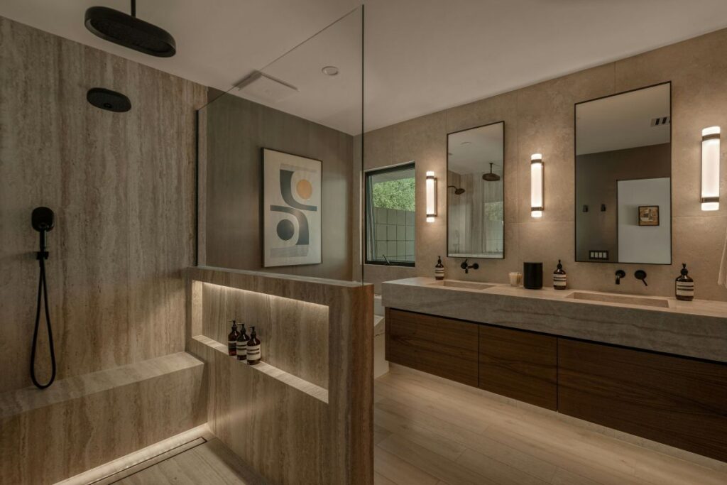 Modern bathroom remodel featuring layered lighting with vanity sconces, recessed ceiling lights, and illuminated shower lighting that enhances the space and improves everyday functionality.